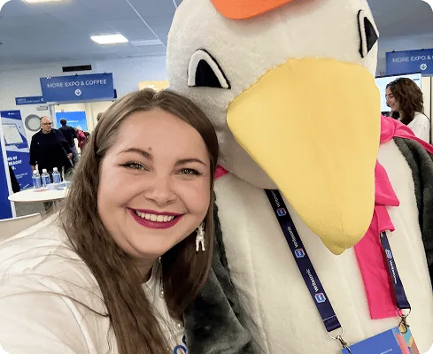Miembro del equipo de Collaborator posando con la mascota de BrightonSEO, una gaviota, en el evento de 2025.