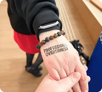 Tatuaje temporal «Professional Overthinker» en la mano de un asistente al Baltic-Nordic SEO Summit 2026.