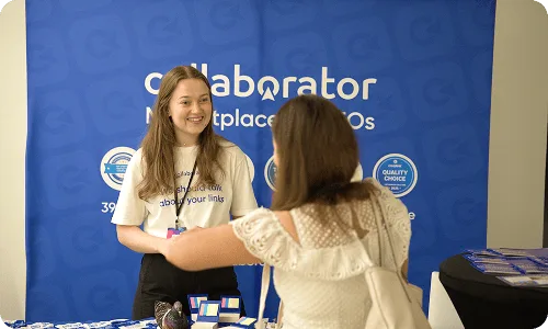 Representante de Collaborator hablando con un asistente en el stand de Croatia SEO Summit.