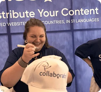 Miembro del equipo de Collaborator personalizando una gorra de la marca en el stand durante SEO Mastery Summit 2025.